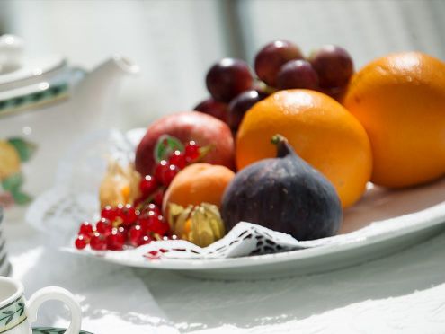 Angerichteter Obstteller mit Orangen, Trauben, Aprikosen, Feigen und Johannisbeeren