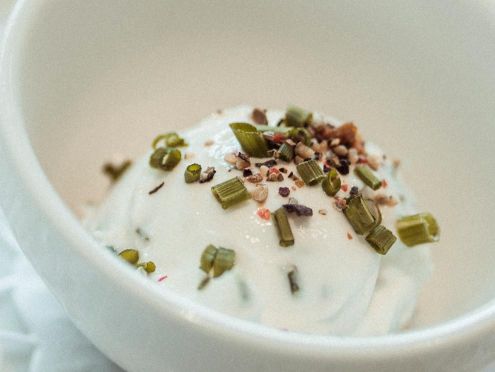 Quarkspeise dekoriert mit Nüssen und Kräutern